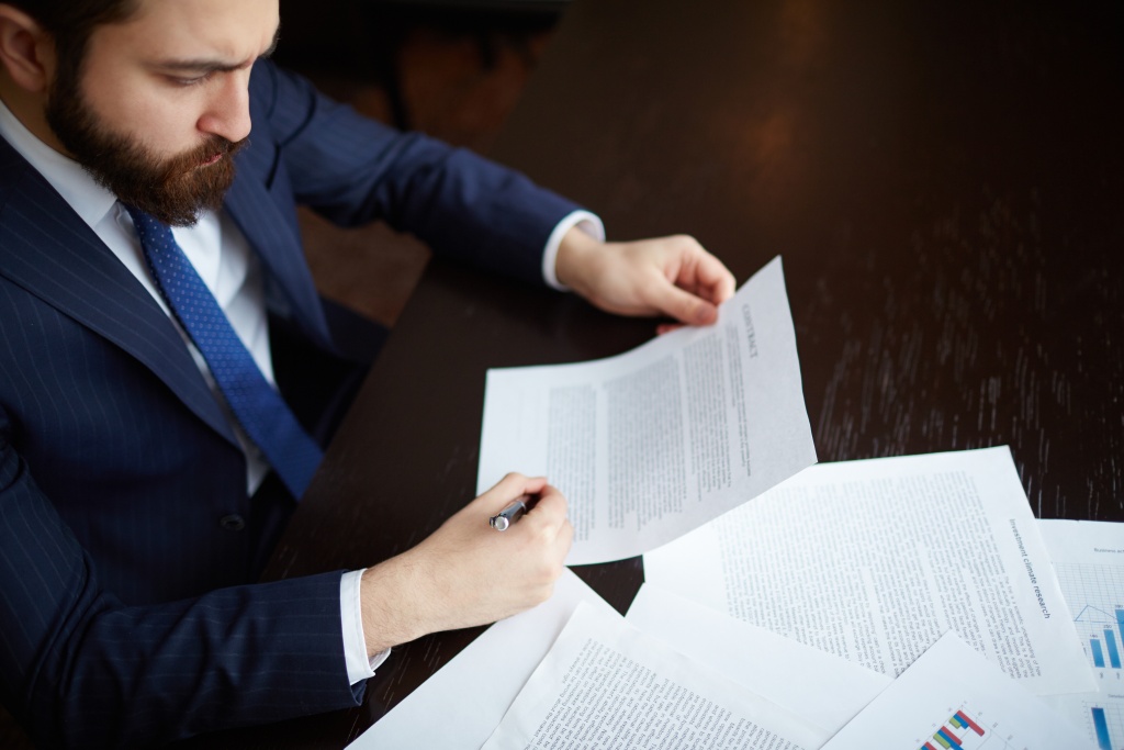 confident-entrepreneur-reviewing-contract.jpg бумаги